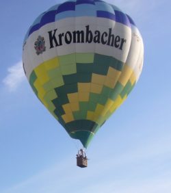 Unser Krombacher Heißluftballon: Das Prinzip ist einfach. Warme Luft ist spezifisch leichter als kalte und steigt deshalb auf. Ein moderner Heißluftballon besteht im Wesentlichen aus vier Teilen: Ballonhülle, Passagiergondel dem Korb, Ballonbrenner und den Treibstoffzylindern. Die Ballonhülle ist aus leichtem, luftundurchlässigem beschichtetem Nylon genäht. Die Passagiergondel der Korb wird, wie vor 200 Jahren, aus Weidenrohr geflochten. Die Luft in der Ballonhülle wird durch einen Gasbrenner erhitzt. Der Treibstoff ein Propan Butangemisch wird in speziellen Treibstoffzylindern mitgeführt.